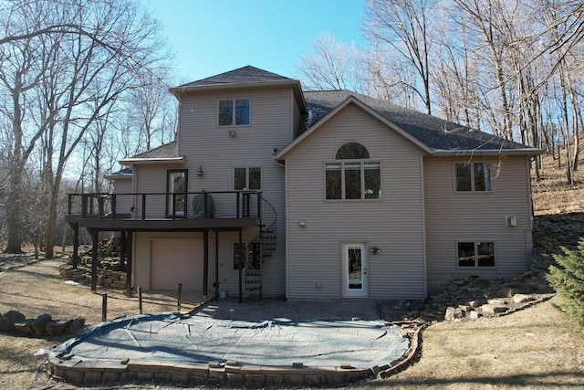 back of house with a wooden deck and a garage