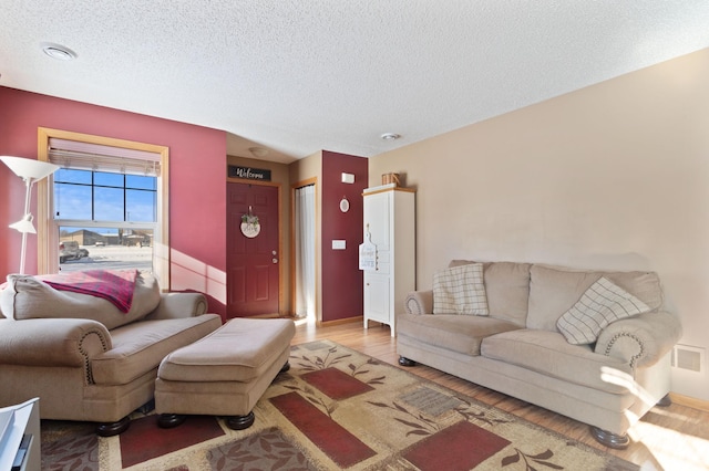 living room with light hardwood / wood-style floors and a textured ceiling