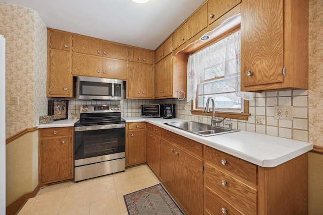 kitchen with tasteful backsplash, sink, light tile patterned floors, and stainless steel appliances