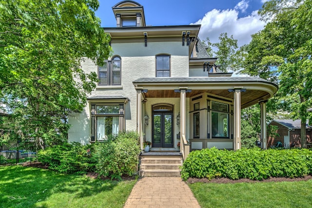 italianate-style house featuring a front lawn and french doors