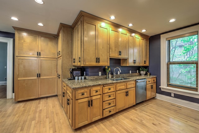 kitchen featuring light stone counters, dishwasher, sink, and light hardwood / wood-style flooring