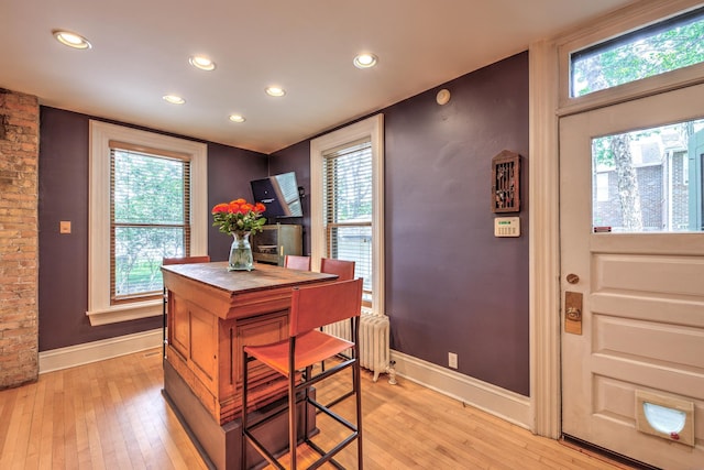 office space with radiator and light wood-type flooring