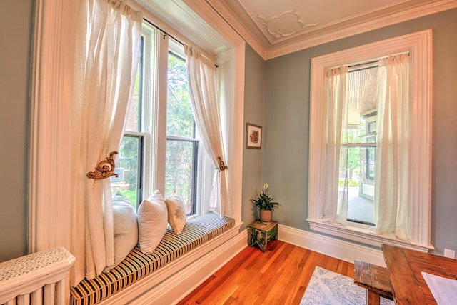 living area with crown molding and hardwood / wood-style floors