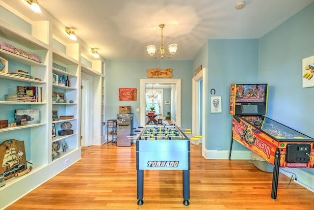 rec room with an inviting chandelier and light wood-type flooring