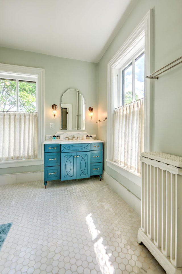 bathroom with a healthy amount of sunlight, radiator heating unit, and vanity