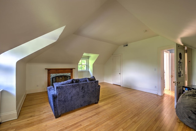 living room with vaulted ceiling and light hardwood / wood-style flooring