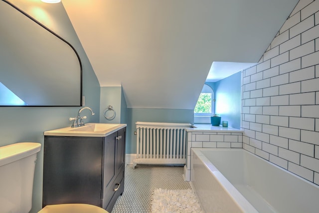 bathroom with vaulted ceiling, radiator heating unit, a bath, vanity, and tile patterned flooring