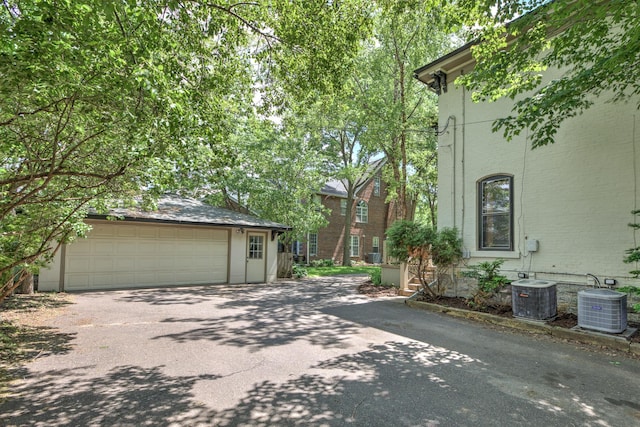 exterior space featuring cooling unit, a garage, and an outbuilding