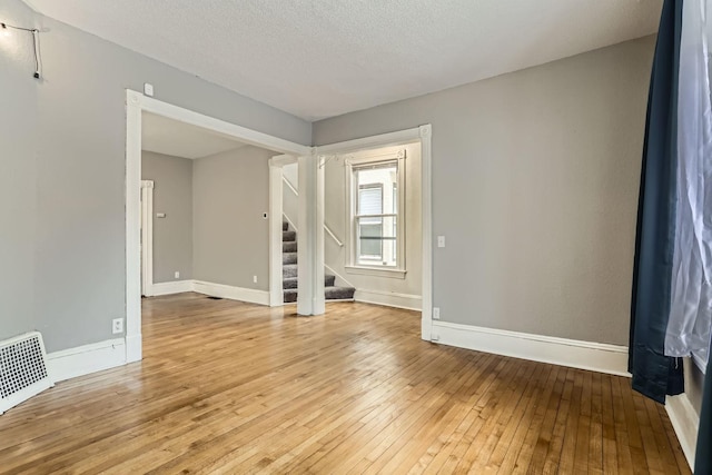 empty room featuring light hardwood / wood-style flooring and a textured ceiling