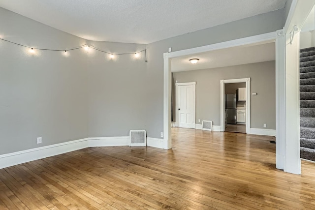 empty room featuring hardwood / wood-style flooring and a textured ceiling