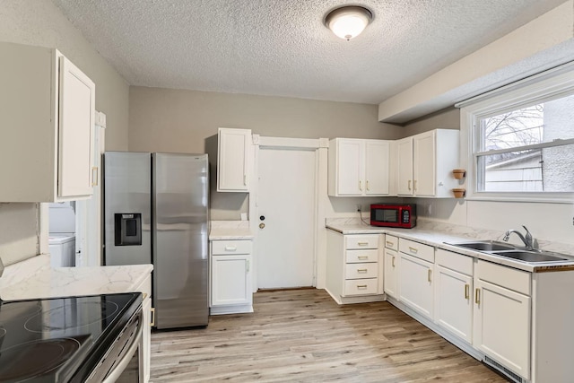 kitchen with sink, stainless steel appliances, a textured ceiling, white cabinets, and light wood-type flooring