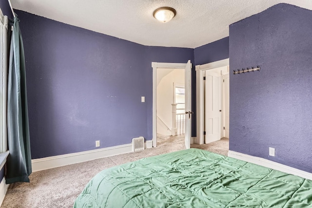 unfurnished bedroom featuring light colored carpet and a textured ceiling