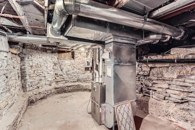 basement featuring electric panel and heating unit