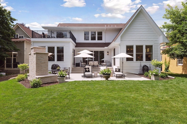 back of house with a yard, a patio area, and a balcony