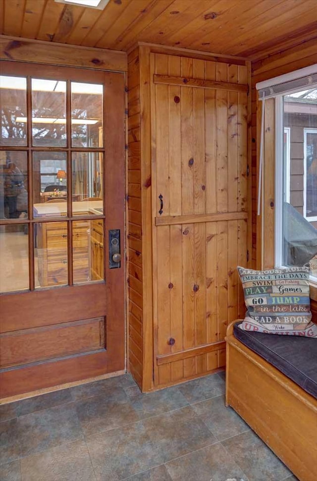 sitting room featuring wood ceiling and wooden walls