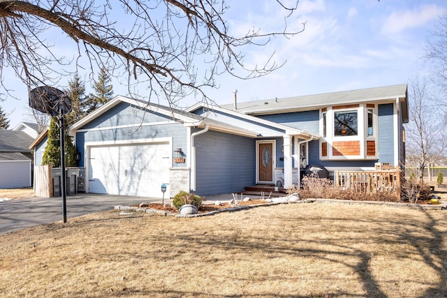 split level home featuring aphalt driveway, a garage, a porch, and entry steps