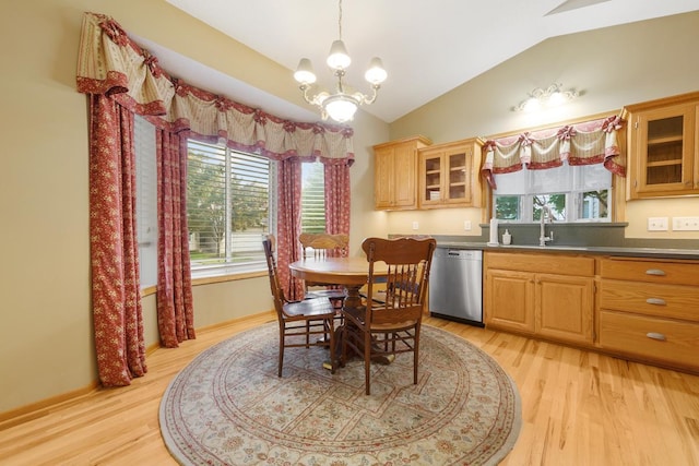 dining area featuring lofted ceiling, sink, an inviting chandelier, and light wood-type flooring