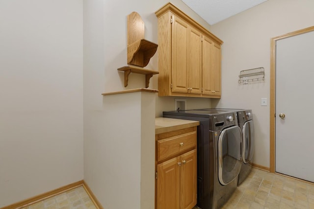 clothes washing area featuring cabinets and washer and dryer