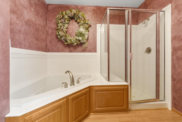 bathroom featuring hardwood / wood-style floors, plus walk in shower, and a textured ceiling