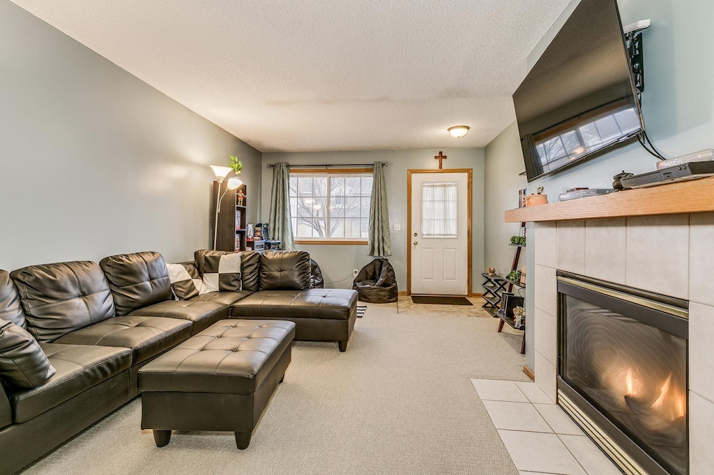 living room with light carpet, a fireplace, and a textured ceiling