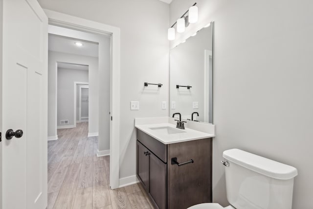 bathroom featuring hardwood / wood-style flooring, vanity, and toilet