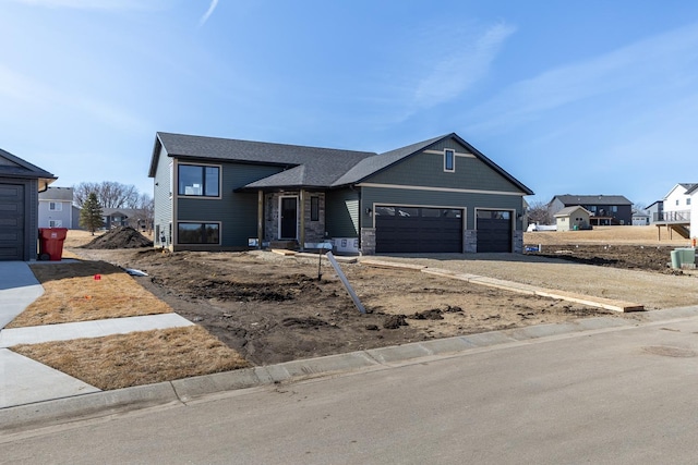 view of front of property featuring a garage and stone siding