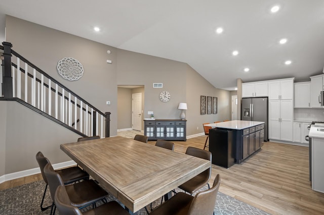 dining room with recessed lighting, stairway, and light wood finished floors