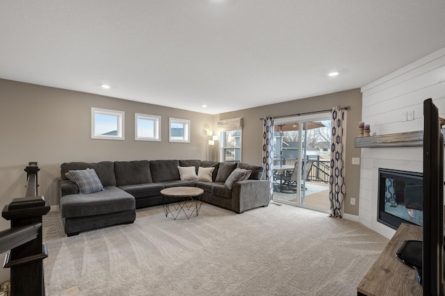 living area featuring carpet, a large fireplace, baseboards, and recessed lighting