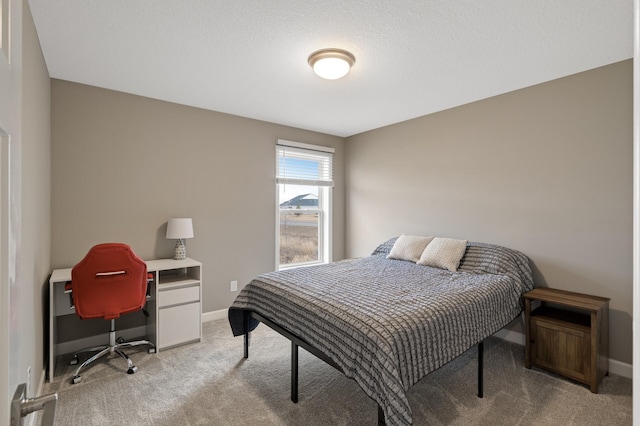 bedroom featuring baseboards, a textured ceiling, and light colored carpet