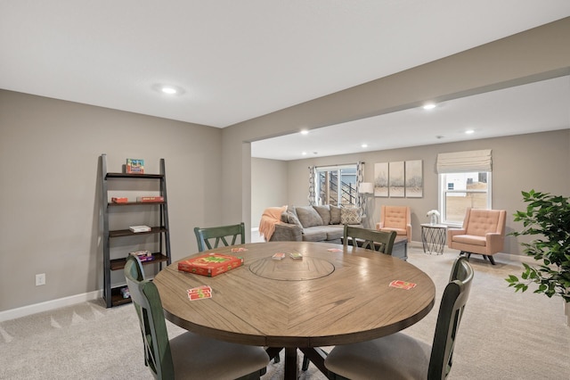 dining space with baseboards, recessed lighting, and light colored carpet