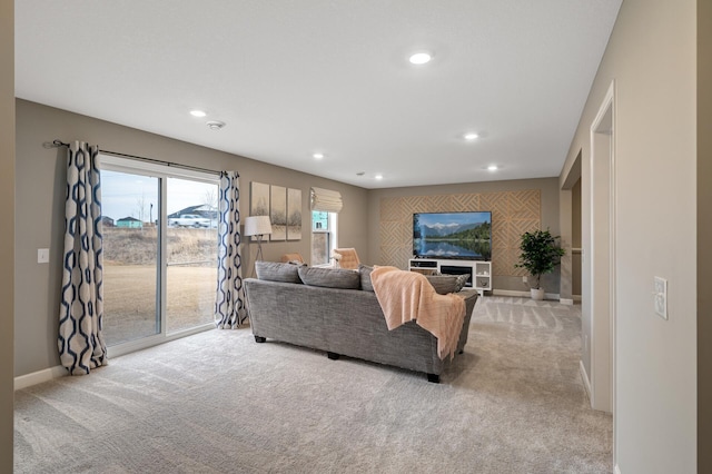 living area with light carpet, recessed lighting, and baseboards