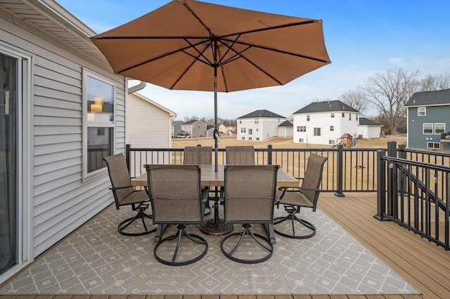 wooden terrace featuring a residential view and outdoor dining area