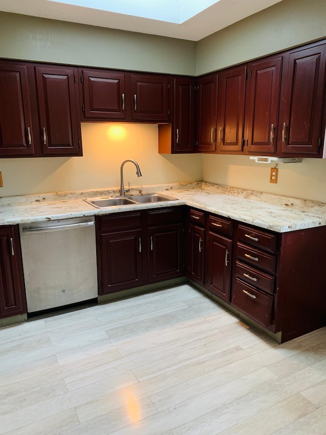 kitchen with sink, stainless steel dishwasher, light wood-type flooring, and a skylight