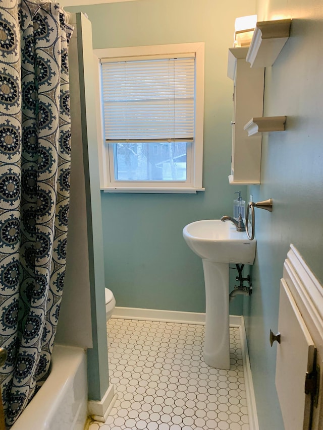 bathroom featuring shower / bath combo and toilet