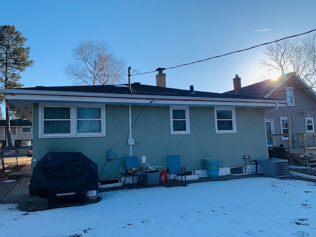 snow covered back of property with cooling unit