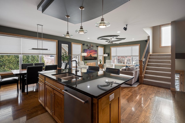 kitchen with pendant lighting, sink, a center island with sink, dark hardwood / wood-style flooring, and stainless steel dishwasher