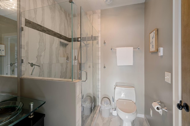 bathroom with vanity, a shower with shower door, and toilet