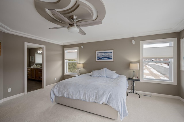 carpeted bedroom featuring crown molding, ceiling fan, and ensuite bath