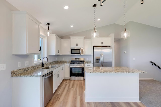 kitchen featuring pendant lighting, white cabinetry, sink, a center island, and stainless steel appliances