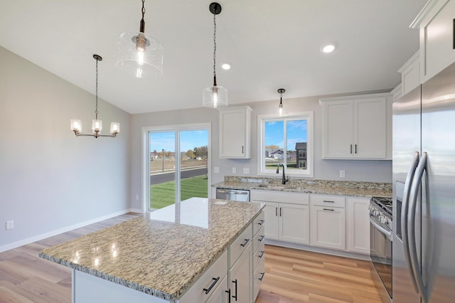 kitchen featuring stainless steel appliances, a kitchen island, and white cabinets