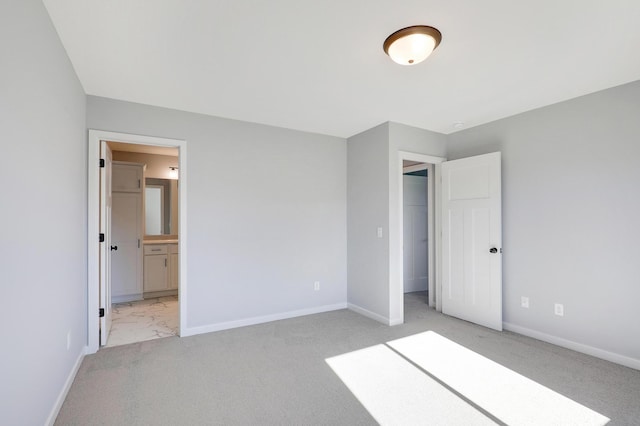 unfurnished bedroom featuring ensuite bath and light carpet