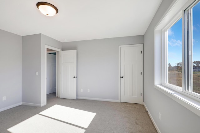 unfurnished bedroom with light colored carpet and a closet