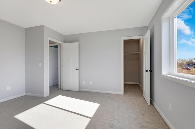 carpeted bedroom featuring multiple windows, a spacious closet, and a closet