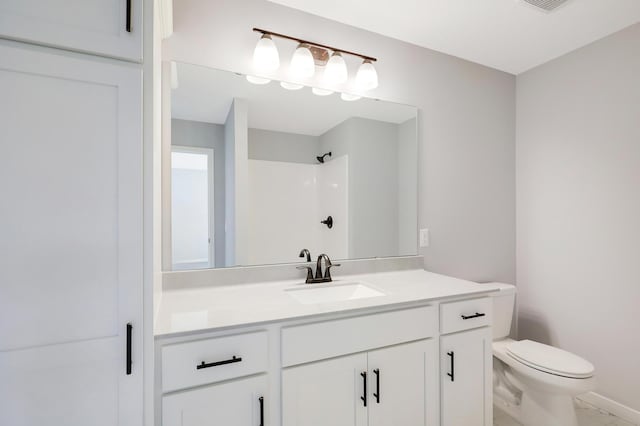 bathroom with vanity, toilet, and a shower