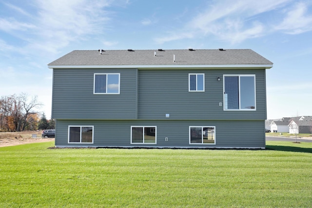 rear view of house featuring a yard