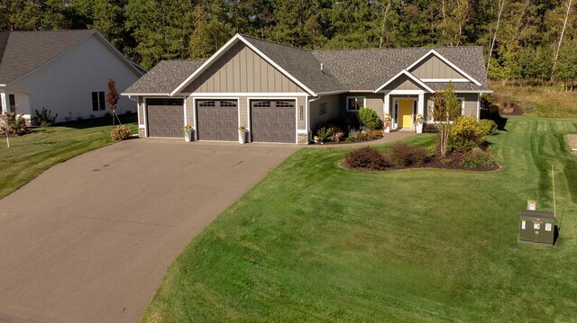 craftsman house with a garage and a front lawn