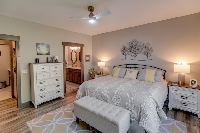 bedroom featuring ceiling fan, ensuite bath, and light hardwood / wood-style flooring