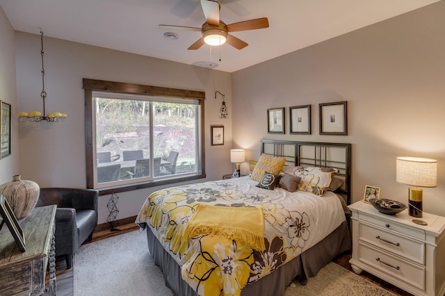 bedroom featuring light hardwood / wood-style floors and ceiling fan with notable chandelier