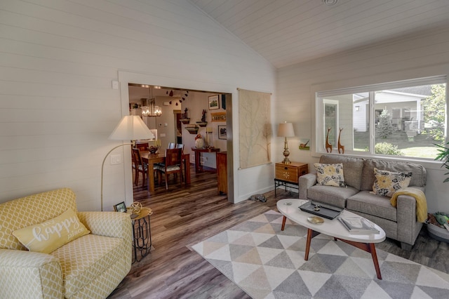 living room featuring a notable chandelier, wood-type flooring, and high vaulted ceiling