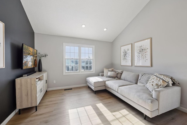 living room with lofted ceiling and light hardwood / wood-style flooring